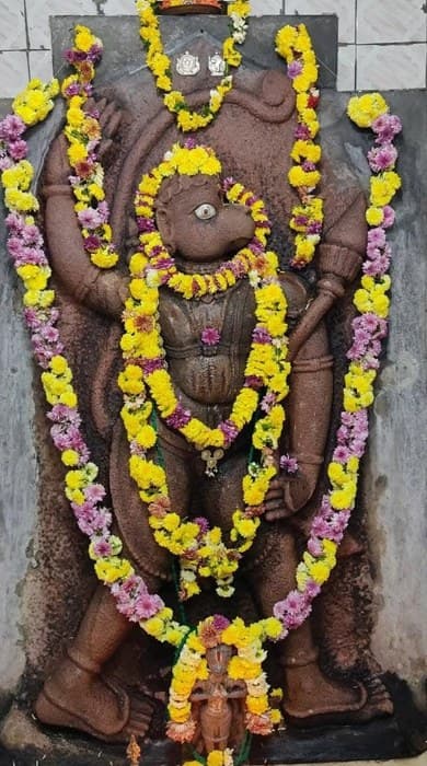 Pranadeva, stone Anjaneya Swamy with garlands and diya